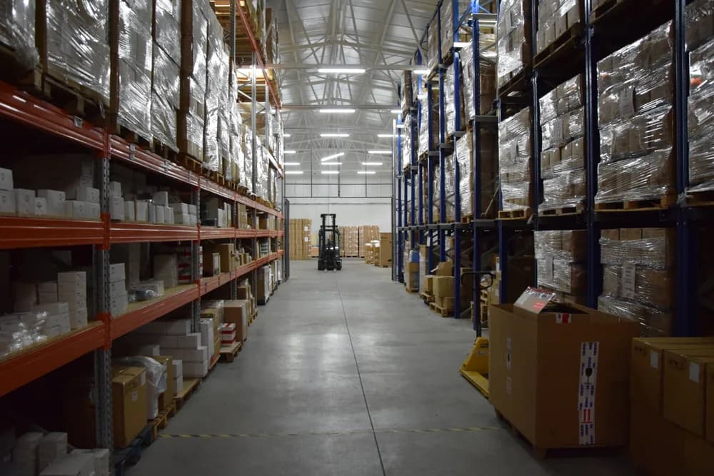 A storage warehouse aisle with racks of wrapped pallets