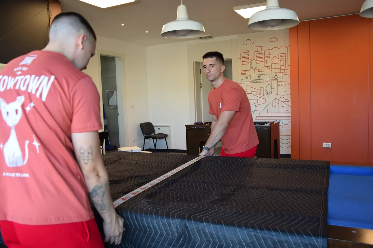 Red Cat commercial movers taping a wrapped pool table