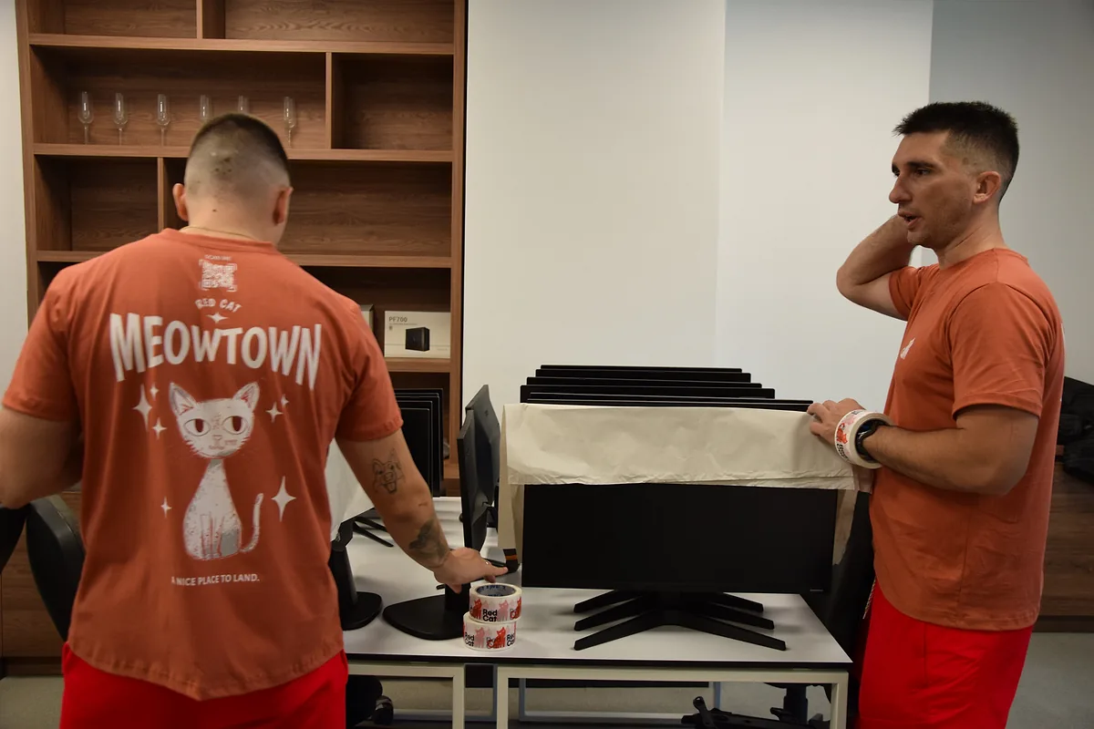 Red Cat movers wrapping a row of office monitors for a corporate move