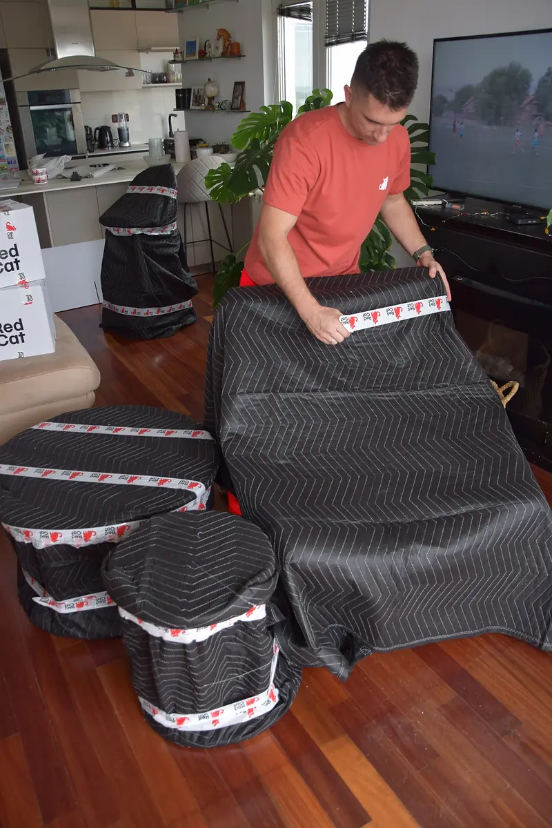 Red Cat mover blanket-wrapping living room furniture