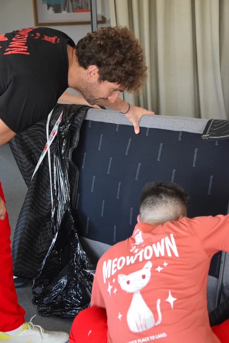 Two Red Cat furniture delivery movers moving a sofa