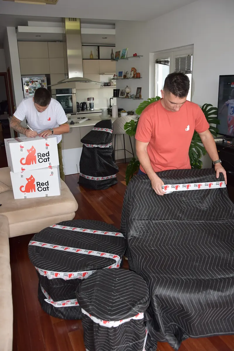 Red Cat long distance movers blanket-wrapping furniture and stools for the drive to another state