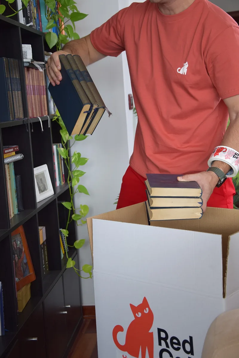 Red Cat long distance mover packing books into a Red Cat box