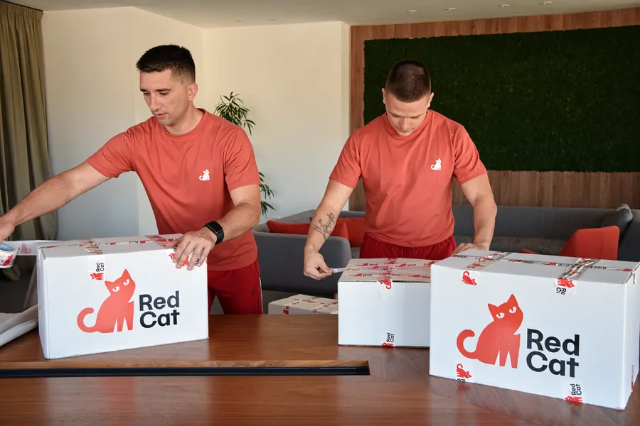 Red Cat local movers packing Red Cat moving boxes in a living room