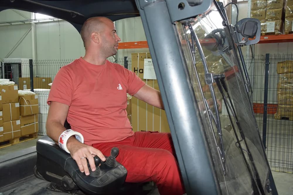 A Red Cat mover at the controls of a forklift