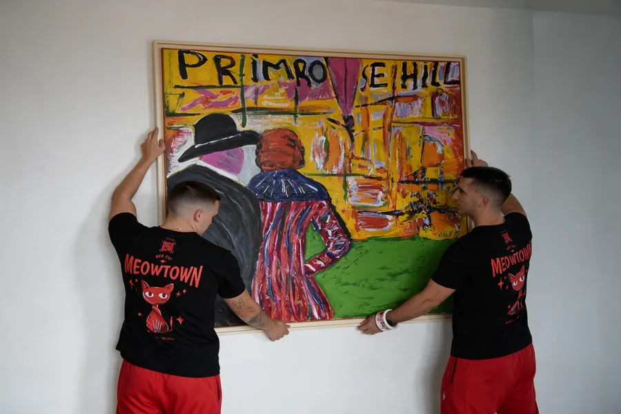 Red Cat white glove movers hanging a painting