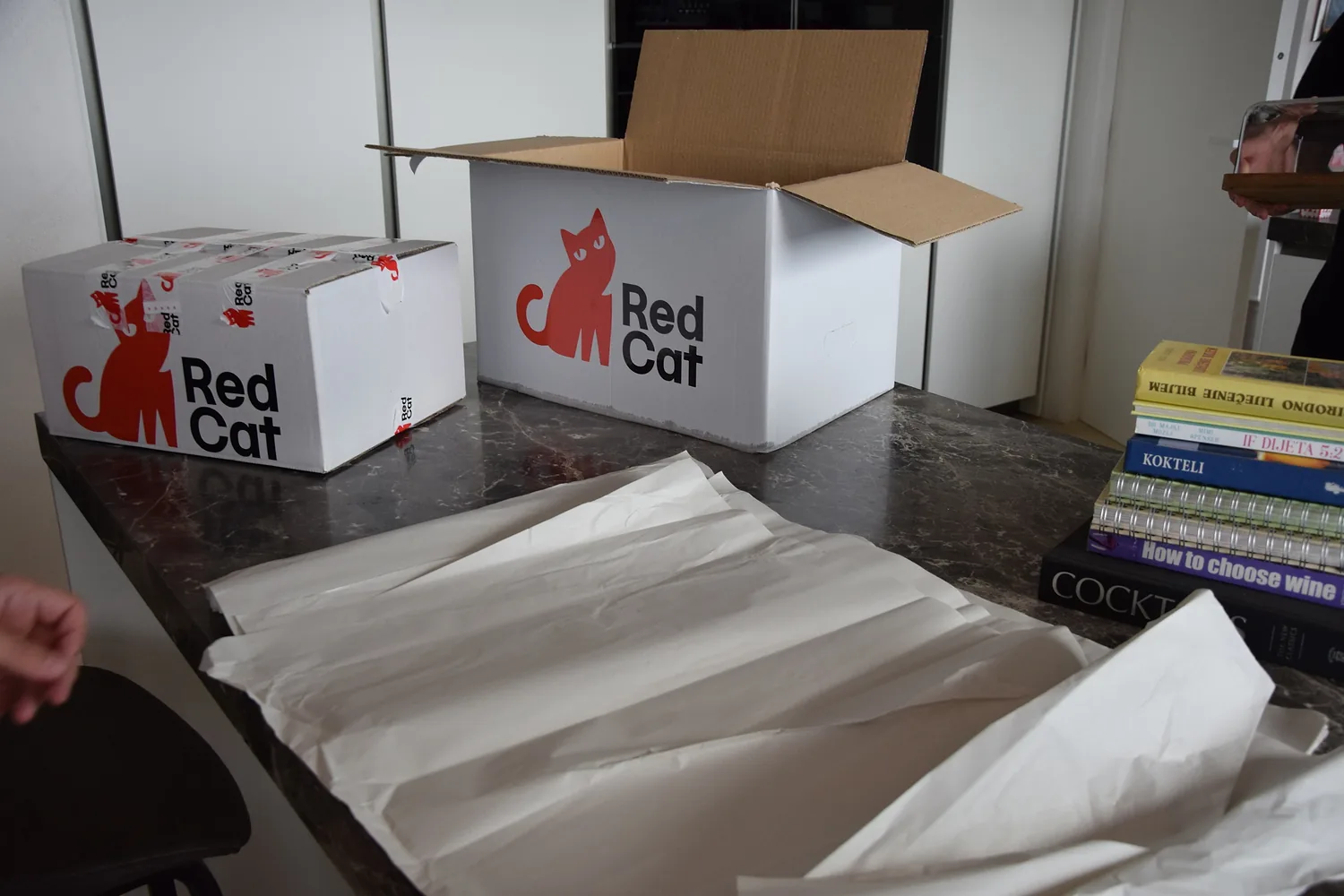 Red Cat boxes and packing paper ready for books in a white glove pack